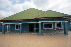 a blue building with a green roof at Yaa Asantewaa Inn in Ejisu