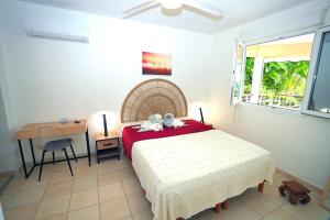 Postel nebo postele na pokoji v ubytování T2 confort zen avec jacuzzi idéal couples jeunes parents proche plage Anse Mitan