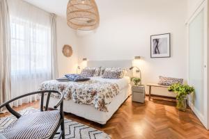 a white bedroom with a bed and a chair at Villa Desiree Pietrasanta in Pietrasanta +82 photos
