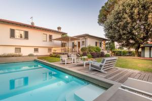 a home with a swimming pool and a house at Villa Desiree Pietrasanta in Pietrasanta