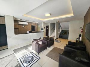 クリシウマにあるOk Inn Hotel Criciúma Centroのリビングルーム(ソファ2台付)、キッチンが備わります。