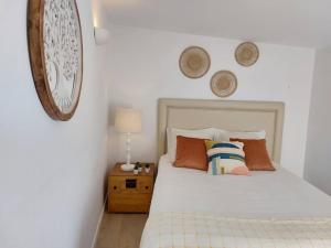 1 dormitorio con cama blanca y reloj en la pared en Apartment Oceans Window, en Ericeira