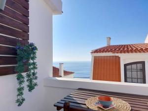 Una mesa en un balcón con vista al mar. en Apartment Oceans Window, en Ericeira
