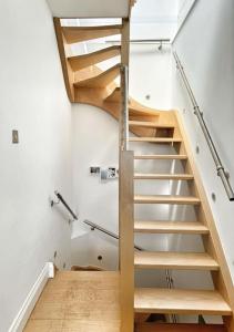 a staircase in a room with white walls and wooden floors at Ancient Lights -Broadstairs Pier in Kent