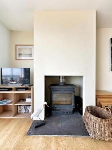 a living room with a fireplace and a chair at Ancient Lights -Broadstairs Pier in Kent