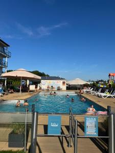 a large swimming pool with people in it at MB Apartments z Basenem i Ogrodem in Sarbinowo