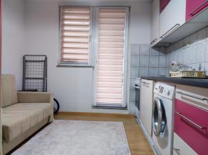 une cuisine avec un canapé et un lave-linge dans l'établissement Amna, à Sarajevo