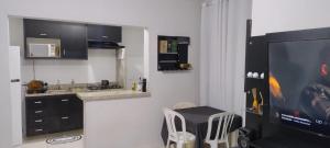 a kitchen with a tv and a table with chairs at Apartamento das Estrelas in Palmas
