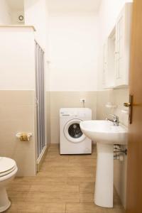 un bagno con lavatrice e lavandino di Villa con Piscina 150mt dal Mare 8 Posti OA ad Alcamo