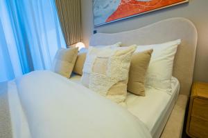 eine weiße Couch mit Kissen neben einem Fenster in der Unterkunft Elegant Studio with Pool Access & Private Terrace in Dubai