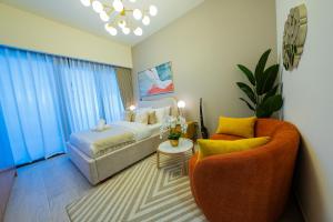 ein Hotelzimmer mit einem Bett und zwei Stühlen in der Unterkunft Elegant Studio with Pool Access & Private Terrace in Dubai + 39 Fotos