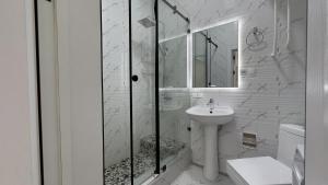 un bagno bianco con doccia e lavandino di Modern 2BR Luxury -10 Min Walk to Old Town a Bukhara