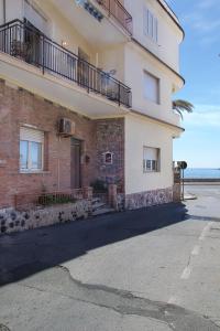een bakstenen gebouw met een balkon aan de zijkant bij Apartment Tysandros in Giardini Naxos