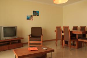 a living room with a table and a tv and chairs at Akisol Albufeira Aqua II in Albufeira