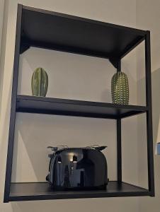 - une étagère avec deux vases et un grille-pain dans l'établissement Top Lacus-by Goccia di Lago, à Desenzano del Garda