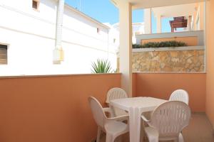 a white table and chairs on a balcony at Akisol Albufeira Aqua II in Albufeira