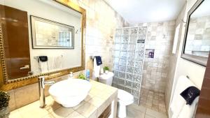 a bathroom with a sink and a toilet and a mirror at San Angel Villas in San Antonio