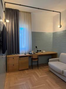 a living room with a desk and a couch at Re Versiliana Hotel in Marina di Pietrasanta