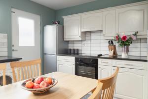 una cucina con un tavolo con una ciotola di frutta sopra di Tawny Lodge Aviemore at Caledonian Escapes ad Aviemore Altre 11 foto