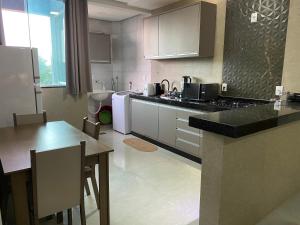 a kitchen with a counter and a table and a counter top at Apartamento 2 Quartos completo in Formosa