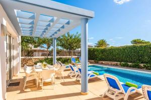 a patio with chairs and a swimming pool at Villa Mar in Cala'n Bosch
