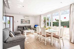 a living room with a couch and a table and chairs at Villa Mar in Cala'n Bosch