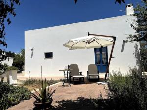 a patio with a table and an umbrella and chairs at Villa Da Mimmo a 350 mt dal mare in Campomarino
