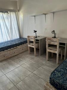 a room with a bed and a desk with two lamps at Mos Elkin Home in Kimberley