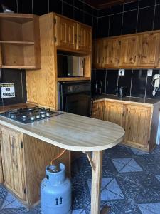 a kitchen with wooden cabinets and a table in it at Mos Elkin Home in Kimberley
