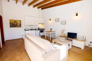 a living room with a white couch and a kitchen at St Johns Countryside Getaway in Odiáxere