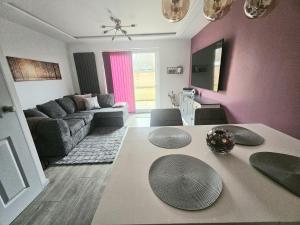 a living room with a couch and a table at Jasmin's House, 2 bedroom, Private Parking in Northampton