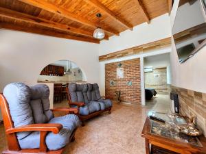 Una sala de estar con un sofá y sillas y una mesa. en Huerta Grande 2, en Huerta Grande