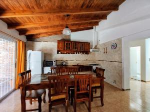 a kitchen with a wooden table and wooden ceilings at Huerta Grande 2 in Huerta Grande