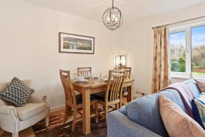 a dining room with a table and chairs and a couch at The Willows in Oxwich