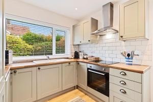 a kitchen with white cabinets and a window at The Willows in Oxwich +20 photos