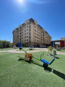 un parco giochi con giocattolo di fronte a un edificio di Modern 2BR Luxury -10 Min Walk to Old Town a Bukhara