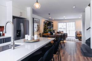 eine Küche und ein Wohnzimmer mit einer Theke und einem Esszimmer in der Unterkunft Modern Mont Blanc Ski in Ski out Townhouse in Saint-Faustin