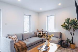 ein Wohnzimmer mit Sofa und Tisch in der Unterkunft Modern Mont Blanc Ski in Ski out Townhouse in Saint-Faustin