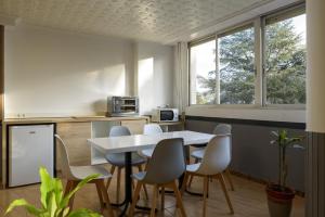 a kitchen with a white table and chairs at Alda Narón in Narón