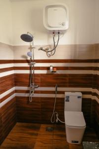 a bathroom with a shower and a toilet in it at Rawana Mountain View Homestay in Ella