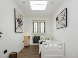 a white bedroom with a bed and a window at The Mooring in Bideford