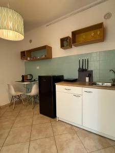 eine Küche mit einem schwarzen Kühlschrank und einem Tisch in der Unterkunft Pardus Domus HOWME in Bari
