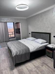 a bedroom with a large bed and a large window at On The Way Apartment in Getapʼ