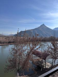 a lake with a bench and a mountain in the background at On The Way Apartment in Getapʼ