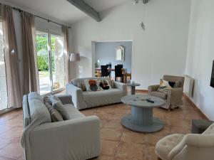Una sala de estar con sofás y una mesa. en Le Mazet Des Joncs en Provence, en Saint-Pierre-de-Vassols