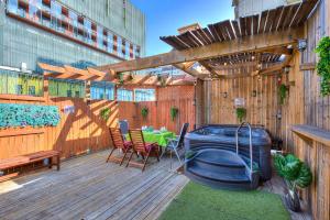 una terraza con bañera de hidromasaje, mesa y sillas en Premier destination for Big Groups MTL Vacation and Nightlife, en Montreal