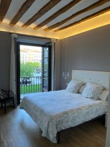 Un dormitorio con una cama y una ventana grande en En el corazón de Pamplona, en Pamplona