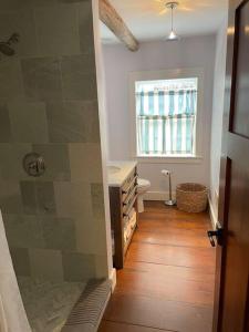 a bathroom with a sink and a toilet and a window at The Doctor 1781 House on the Litchfield Green in Litchfield