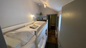 a bedroom with a bed with white sheets at EI8HT Brighton Guest Accommodation in Brighton & Hove