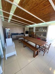 une salle à manger avec une table et des chaises en bois dans l'établissement Cobertura 3 suítes com 1 dependência, à Pirangi do Norte